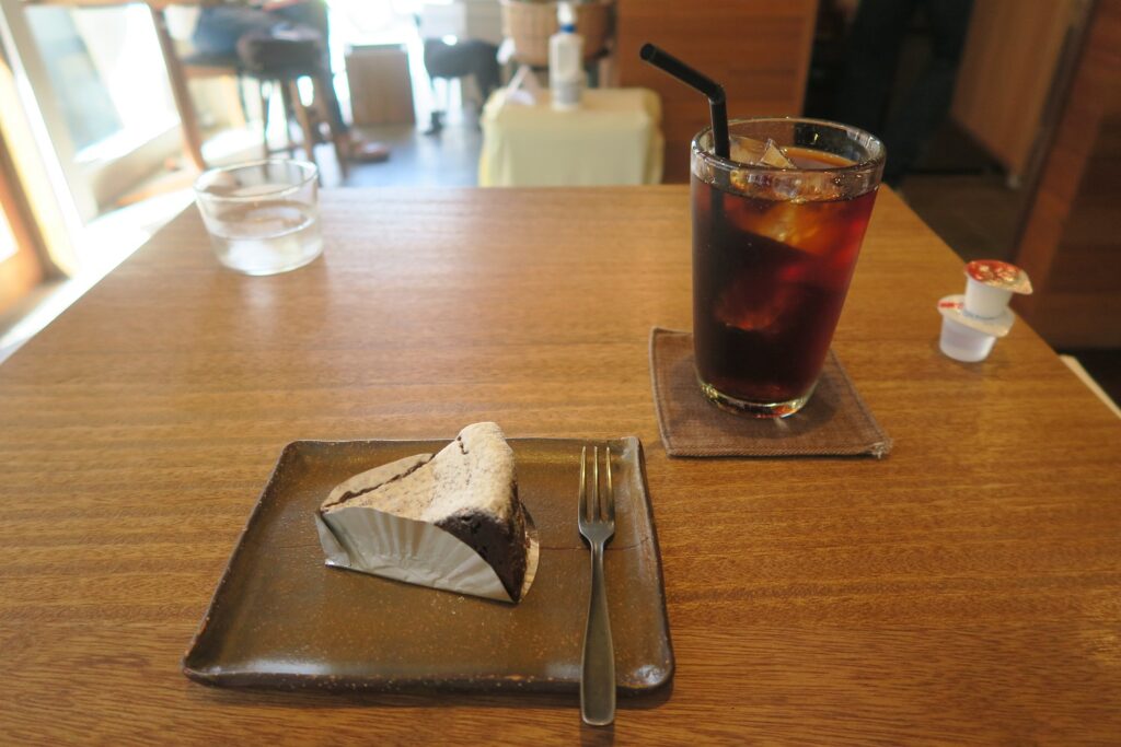 「トックリキワタ珈琲店」のアイスコーヒーとラムレーズンのチョコレートケーキを撮影した写真
