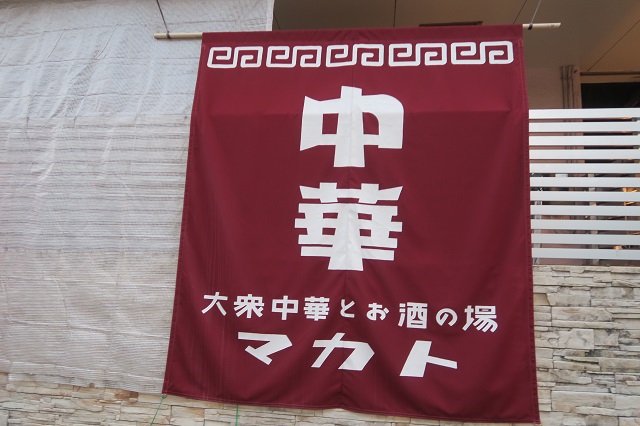 「大衆中華とお酒の場　マカト」の垂れ幕を撮影した写真