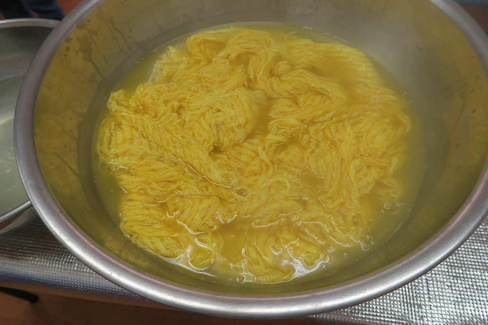 フクギの染液でショールを染める様子を撮影した写真